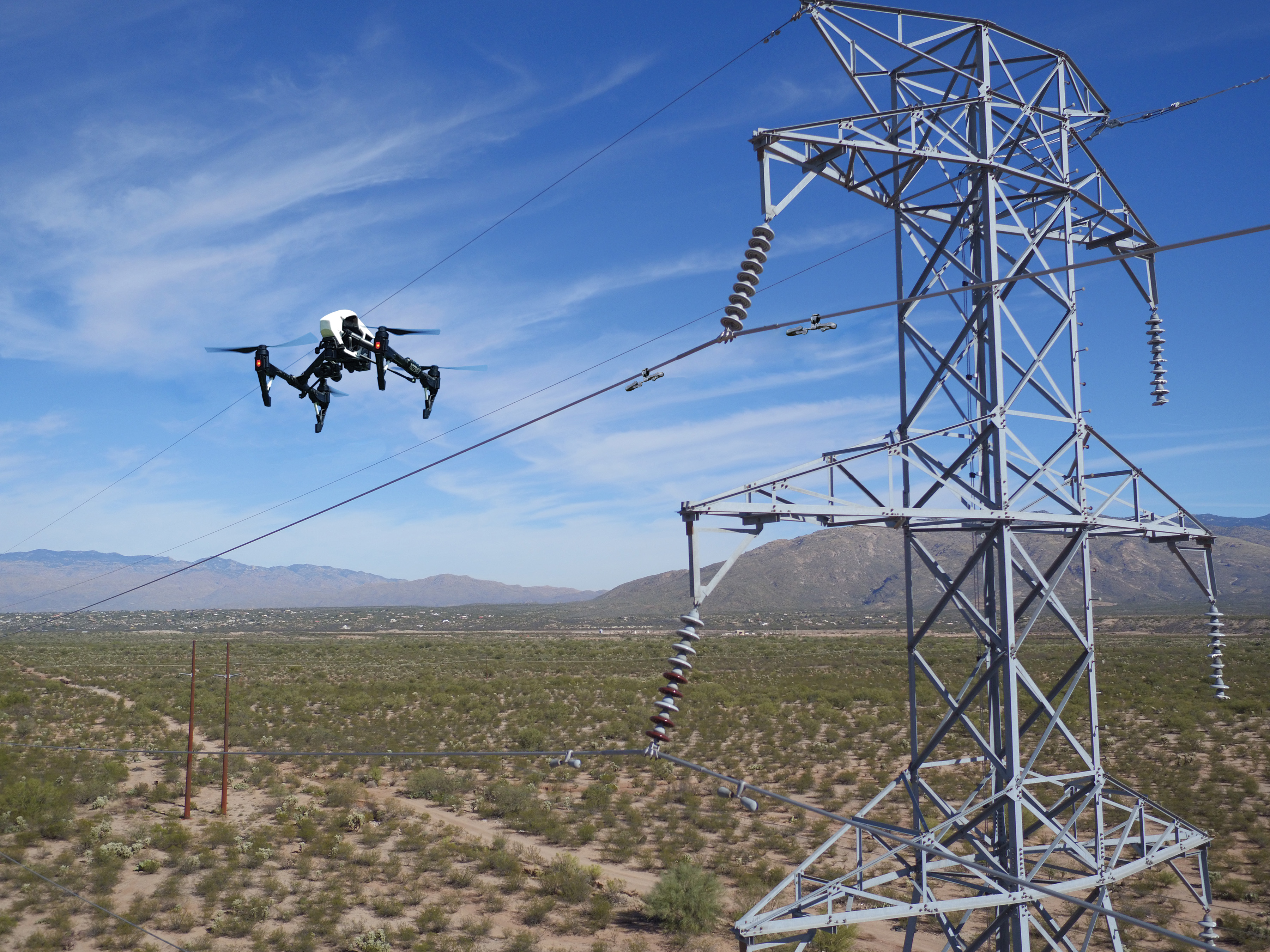 Drone inspecting high-voltage transmission tower
